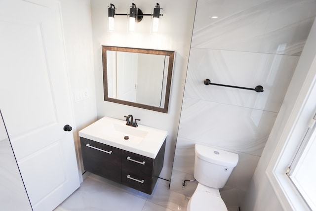 bathroom featuring tile patterned flooring, vanity, toilet, and tile walls