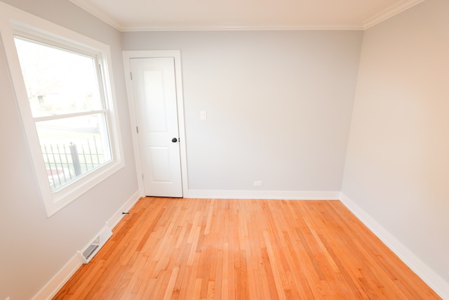 unfurnished room featuring plenty of natural light, ornamental molding, and light hardwood / wood-style flooring