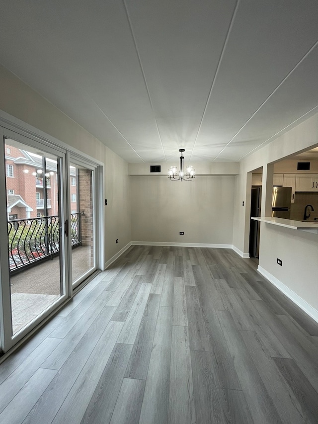 interior space with hardwood / wood-style flooring, sink, and a chandelier