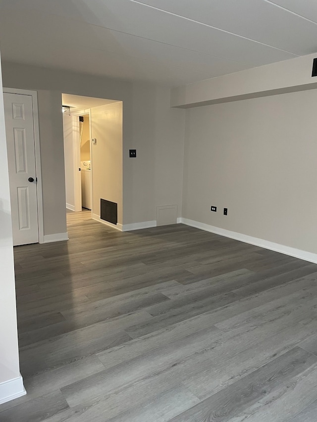 unfurnished room featuring washer / clothes dryer and wood-type flooring