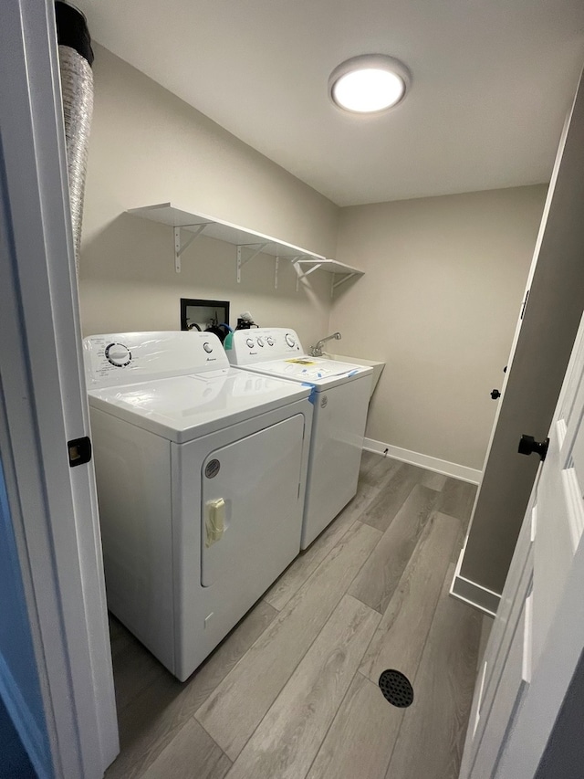 laundry room featuring independent washer and dryer and light wood-type flooring