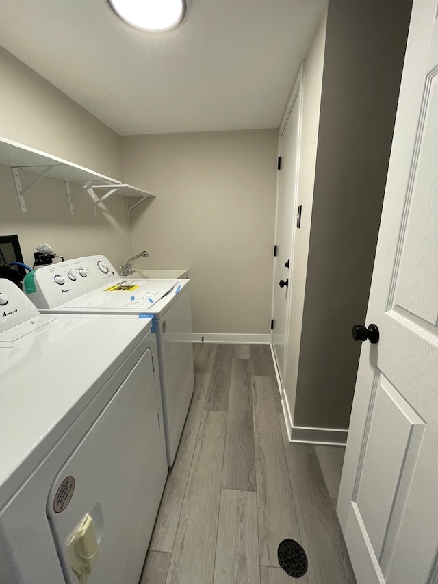 laundry area with separate washer and dryer, hardwood / wood-style floors, and sink