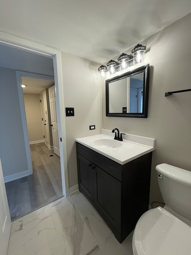 bathroom with vanity, toilet, and wood-type flooring