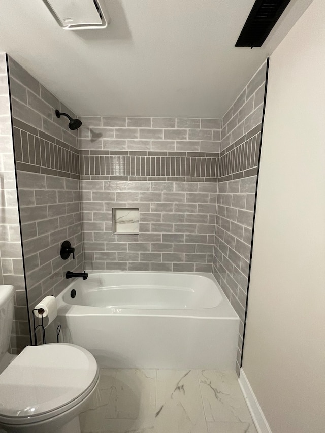 bathroom with tiled shower / bath combo and toilet