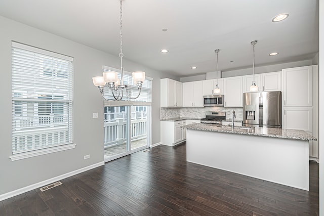 kitchen with a kitchen island with sink, sink, dark hardwood / wood-style flooring, white cabinetry, and stainless steel appliances