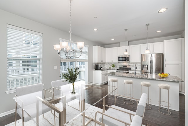 dining room with sink, a chandelier, and dark hardwood / wood-style floors