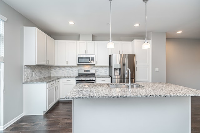 kitchen featuring white cabinets, appliances with stainless steel finishes, dark hardwood / wood-style flooring, and hanging light fixtures