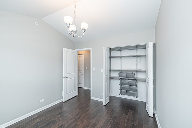 unfurnished bedroom featuring dark hardwood / wood-style flooring, lofted ceiling, and a notable chandelier