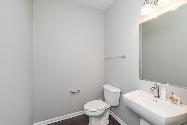 bathroom featuring hardwood / wood-style flooring, toilet, and sink