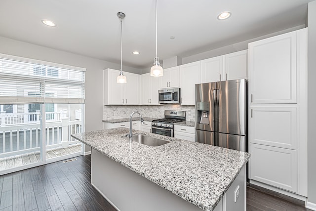 kitchen featuring white cabinets, sink, hanging light fixtures, dark hardwood / wood-style flooring, and stainless steel appliances