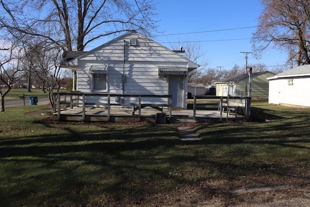 back of property featuring a lawn and a wooden deck