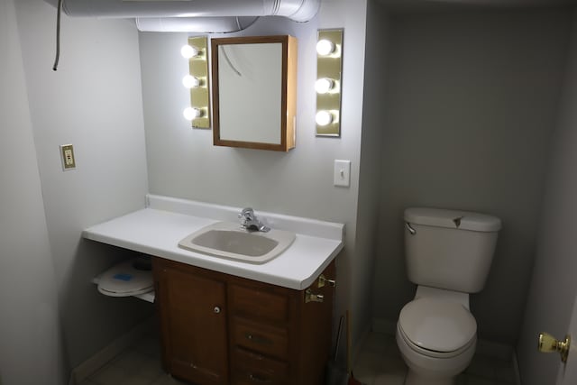 bathroom with tile patterned flooring, vanity, and toilet