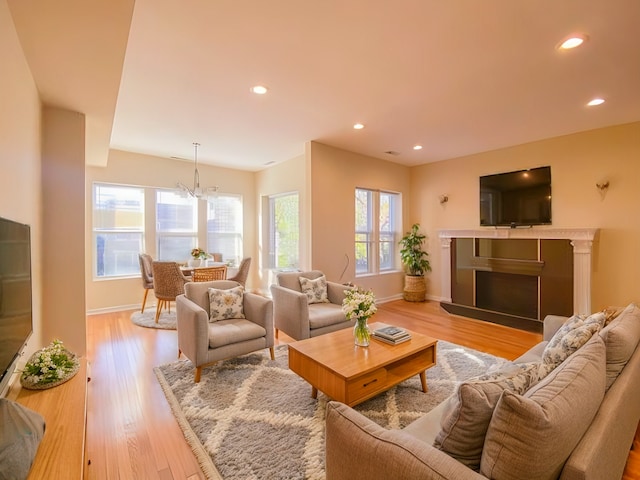 living room featuring light hardwood / wood-style floors and an inviting chandelier