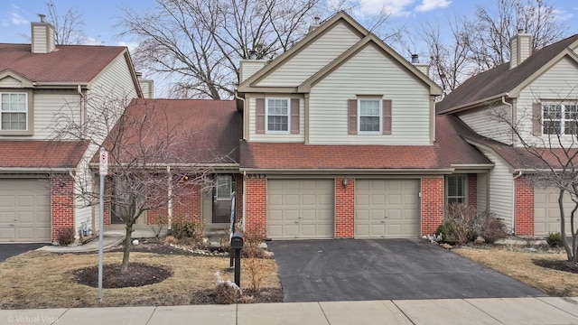 traditional-style home featuring driveway, brick siding, and an attached garage