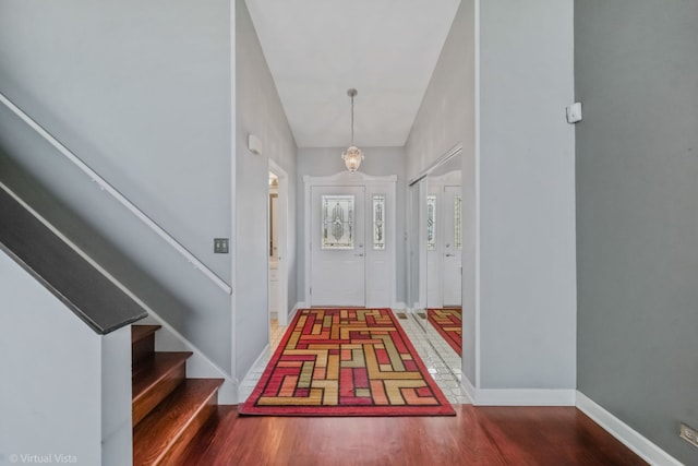 foyer featuring stairway, baseboards, and wood finished floors