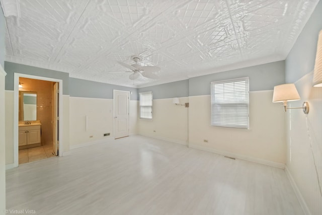 unfurnished bedroom featuring an ornate ceiling, multiple windows, and wood finished floors