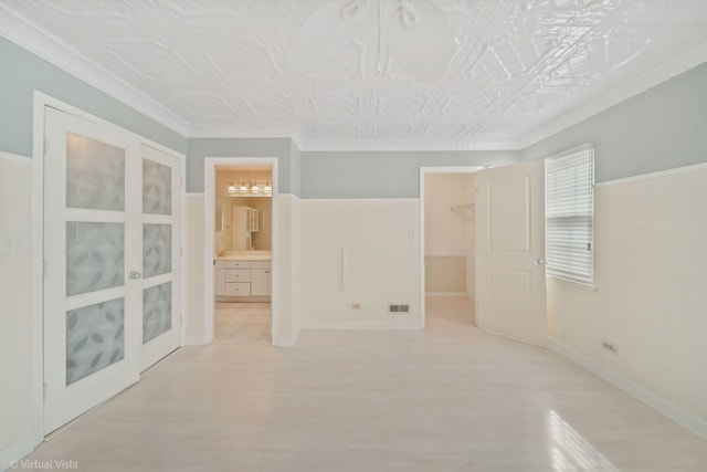 empty room featuring an ornate ceiling, visible vents, baseboards, and wood finished floors