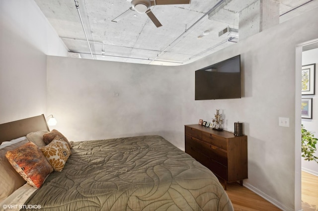 bedroom featuring visible vents, baseboards, wood finished floors, and a ceiling fan