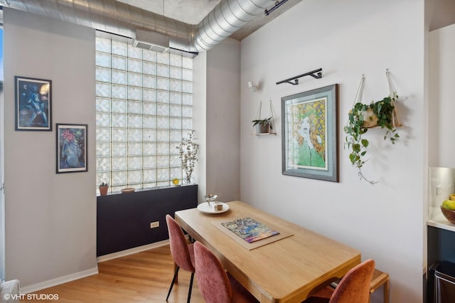 dining area with baseboards and wood finished floors