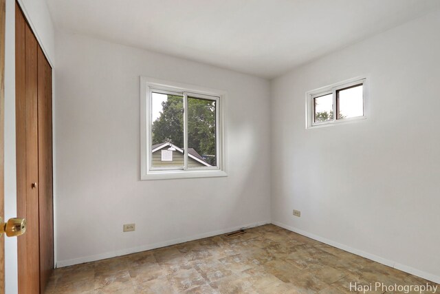 517 Grandview Dr, Round Lake Park, IL 60073 - unfurnished bedroom with baseboards, a closet, and stone finish floors