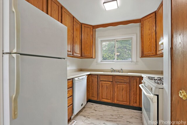 517 Grandview Dr, Round Lake Park, IL 60073 - kitchen with white appliances, light marble finish floors, a sink, brown cabinetry, and light countertops