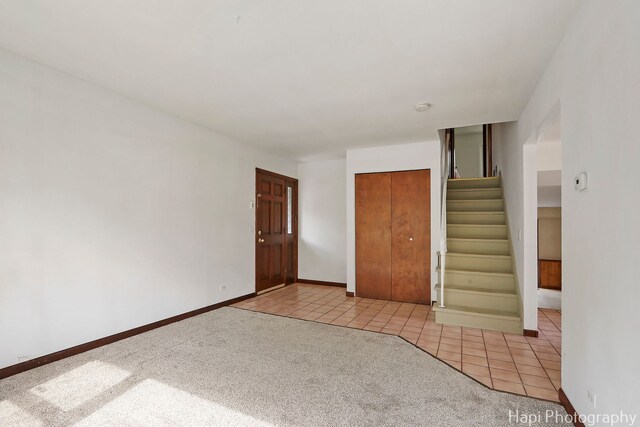 517 Grandview Dr, Round Lake Park, IL 60073 - unfurnished room featuring stairs, light tile patterned floors, light colored carpet, and baseboards