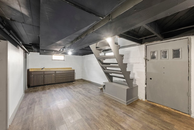1326 Arthur Ave, Joliet, IL 60432 - below grade area featuring light wood-type flooring, stairs, a sink, and baseboards