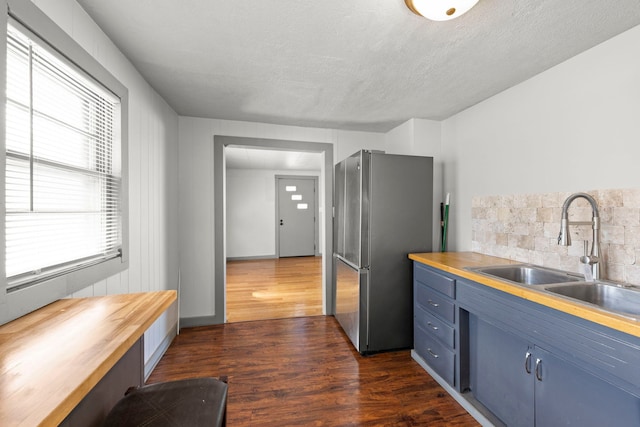 1326 Arthur Ave, Joliet, IL 60432 - kitchen with blue cabinets, freestanding refrigerator, a sink, wooden counters, and dark wood finished floors