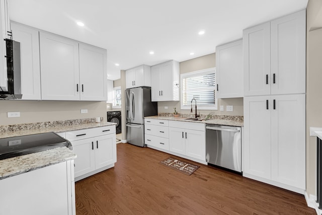 kitchen featuring stainless steel appliances, dark wood-type flooring, sink, washer / clothes dryer, and white cabinetry