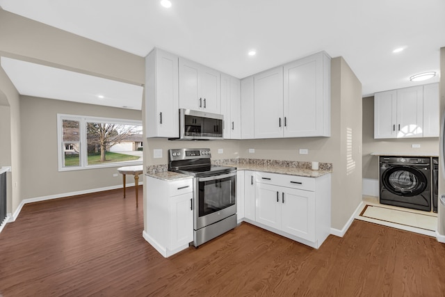 kitchen featuring white cabinets, washer / clothes dryer, and appliances with stainless steel finishes