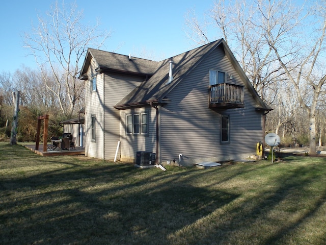 view of side of home featuring a yard and a balcony