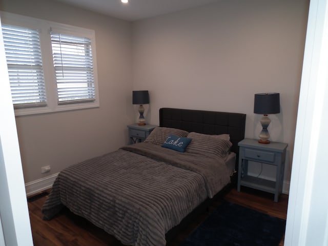 bedroom with dark hardwood / wood-style flooring