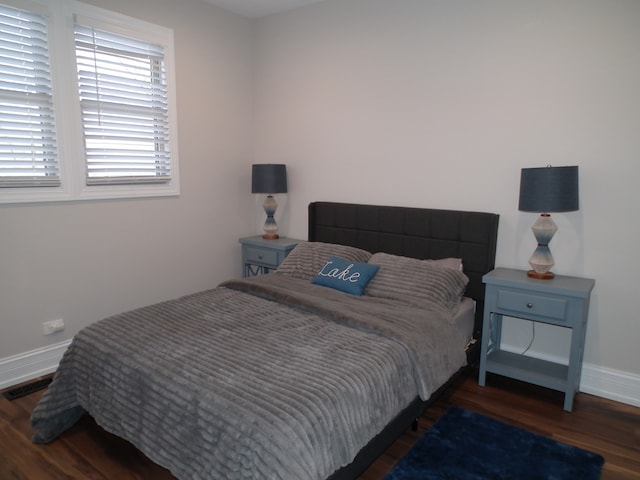 bedroom with dark hardwood / wood-style flooring