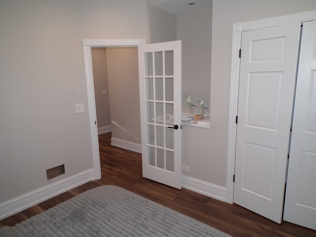 unfurnished bedroom with dark hardwood / wood-style floors and a closet