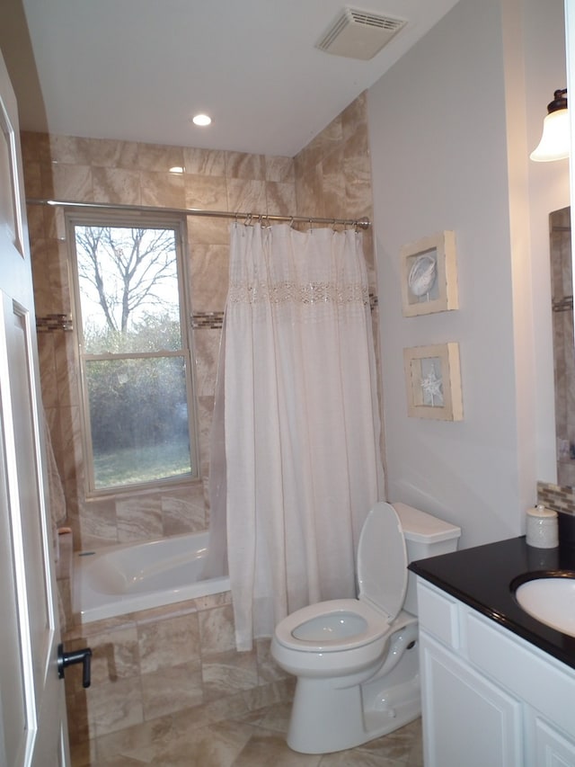 full bathroom featuring shower / bath combo with shower curtain, vanity, and toilet