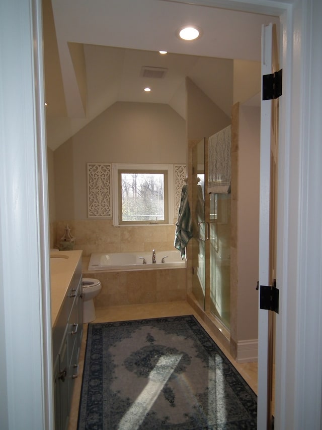 full bathroom with toilet, vanity, separate shower and tub, and lofted ceiling