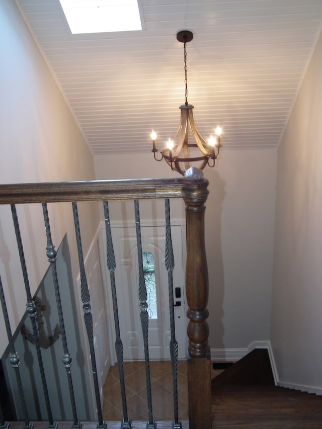 staircase featuring wood-type flooring, an inviting chandelier, and ornamental molding