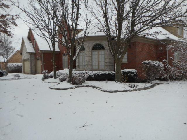 view of snowy exterior featuring a garage