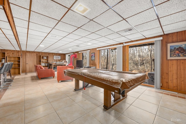 playroom with light tile patterned floors, a drop ceiling, wood walls, and pool table