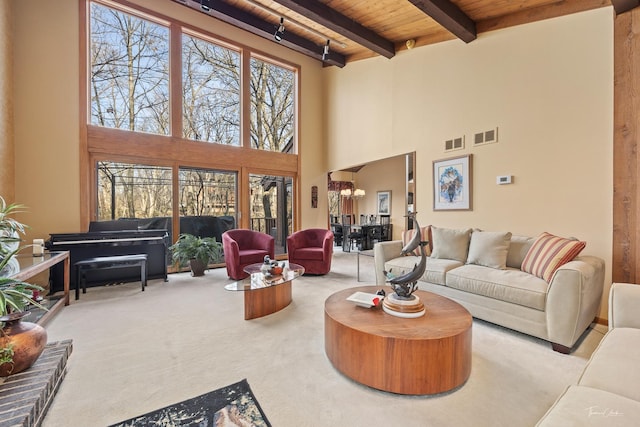 living room with light carpet, beam ceiling, a high ceiling, and wood ceiling