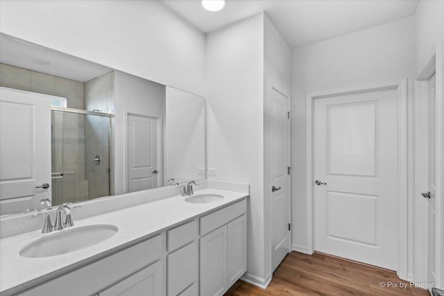 bathroom featuring vanity, hardwood / wood-style flooring, and a shower with door