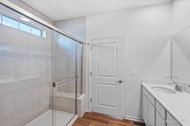 bathroom featuring wood-type flooring, vanity, and a shower with door