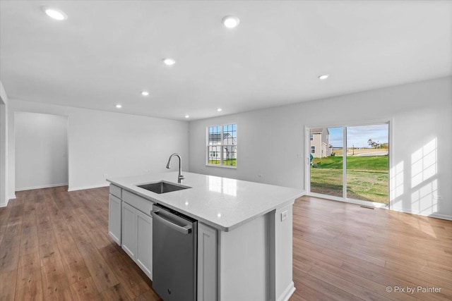 kitchen featuring a center island with sink, dishwasher, light hardwood / wood-style floors, and sink