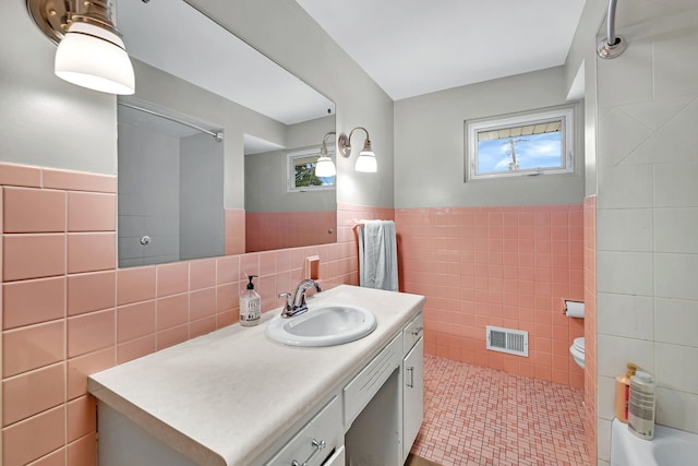 bathroom featuring vanity and tile walls