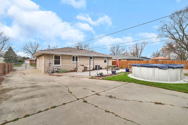 rear view of house with a patio area and a covered pool