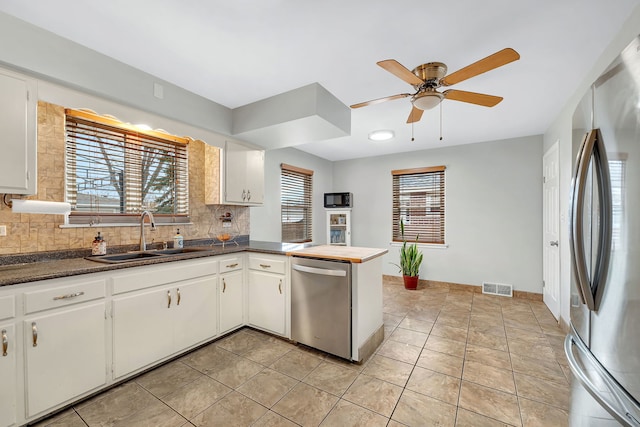 kitchen with sink, white cabinets, a healthy amount of sunlight, and appliances with stainless steel finishes