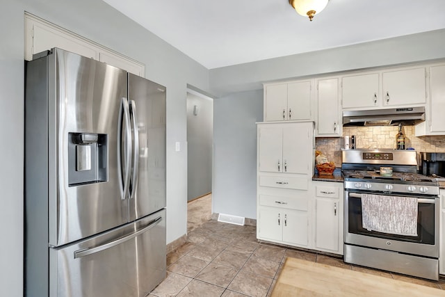 kitchen with decorative backsplash, white cabinets, light tile patterned floors, and appliances with stainless steel finishes