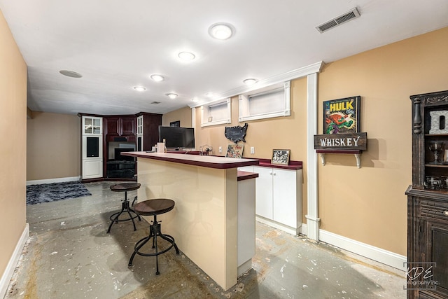 kitchen featuring a kitchen breakfast bar, oven, and kitchen peninsula