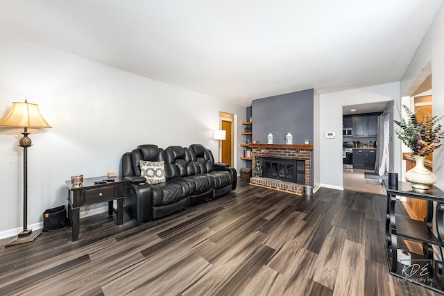 living room featuring a brick fireplace and dark hardwood / wood-style floors