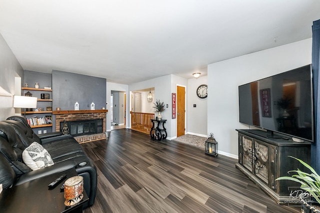 living room featuring a brick fireplace and dark hardwood / wood-style flooring